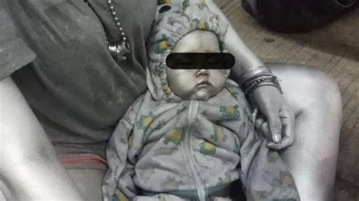 Warped mum lets beggar paint her baby SILVER and cradle it in the street so they can both rake in cash