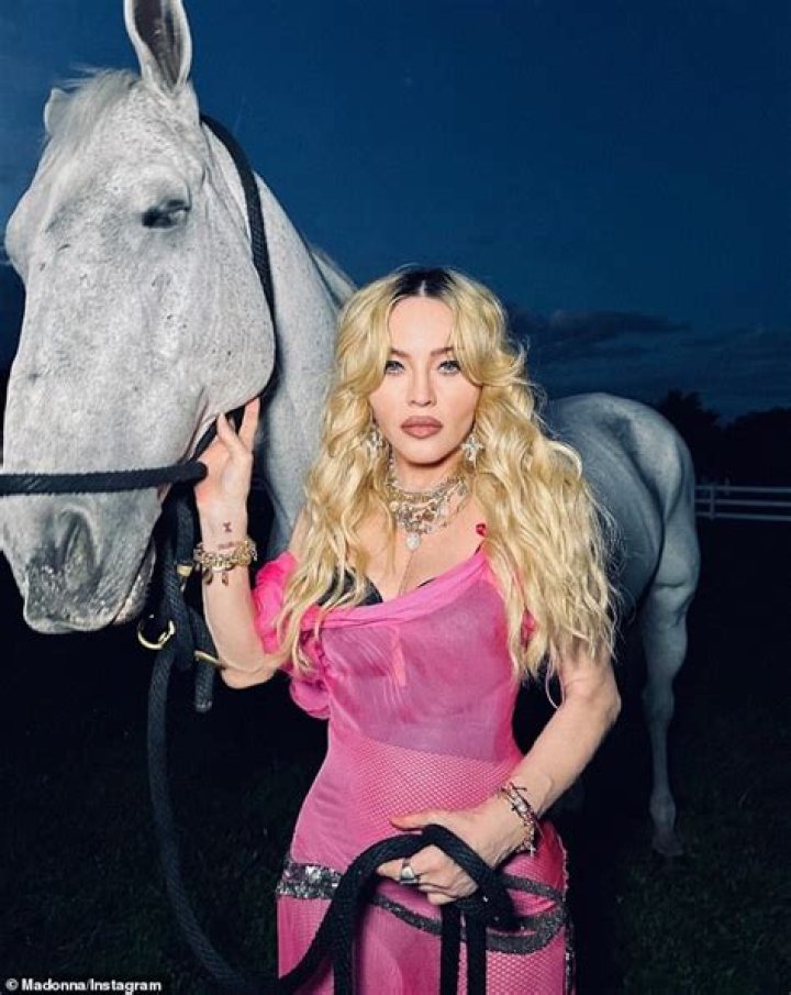 Madonna, 63, goes topless as she writhes on a bed in a skimpy lace thong