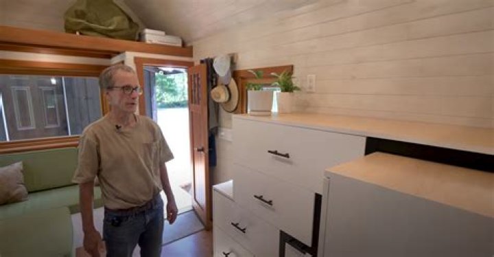 I built my 'tumbleweed' tiny home for under $30,000 and it's two stories but my hidden staircase is the real star